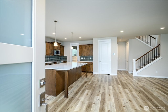 14516 204th Ave E Unit 895, Bonney Lake, WA 98391 - kitchen featuring stainless steel microwave, light countertops, decorative backsplash, recessed lighting, and a center island