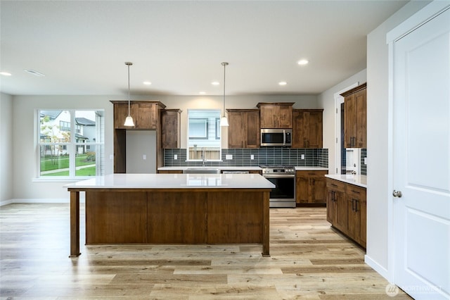 14516 204th Ave E Unit 895, Bonney Lake, WA 98391 - kitchen featuring stainless steel appliances, light wood-style floors, decorative backsplash, a center island, and recessed lighting