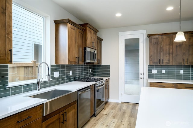 14516 204th Ave E Unit 895, Bonney Lake, WA 98391 - kitchen with appliances with stainless steel finishes, a sink, light wood-style floors, tasteful backsplash, and light countertops