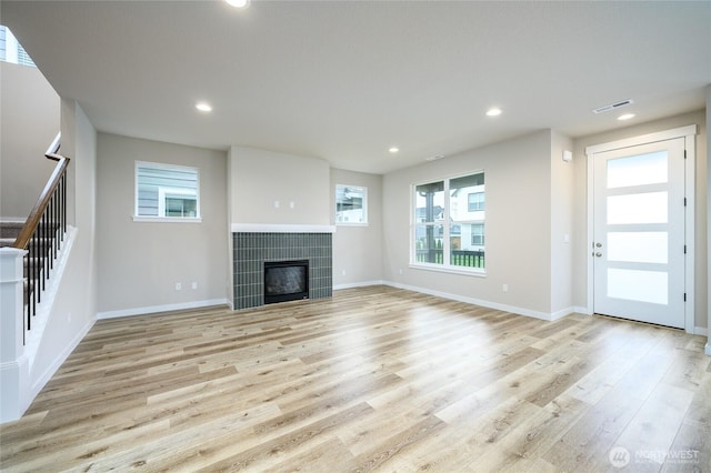 14516 204th Ave E Unit 895, Bonney Lake, WA 98391 - unfurnished living room featuring stairway, light wood-style floors, a fireplace, recessed lighting, and baseboards