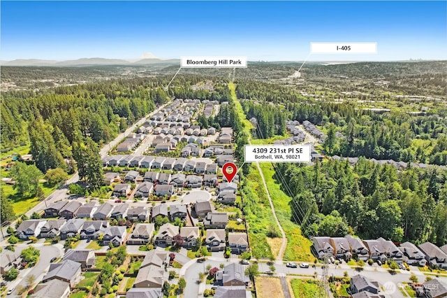 4309 231st Pl SE, Bothell, WA 98021 - aerial overview of property's location with nearby suburban area, a forest, and a mountainous background