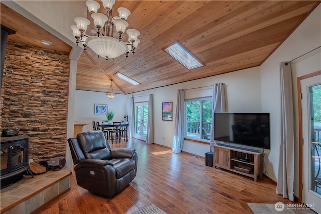 720 N Potlatch Dr N, Hoodsport, WA 98548 - living room with vaulted ceiling, a wood stove, wood ceiling, hardwood / wood-style flooring, and a chandelier