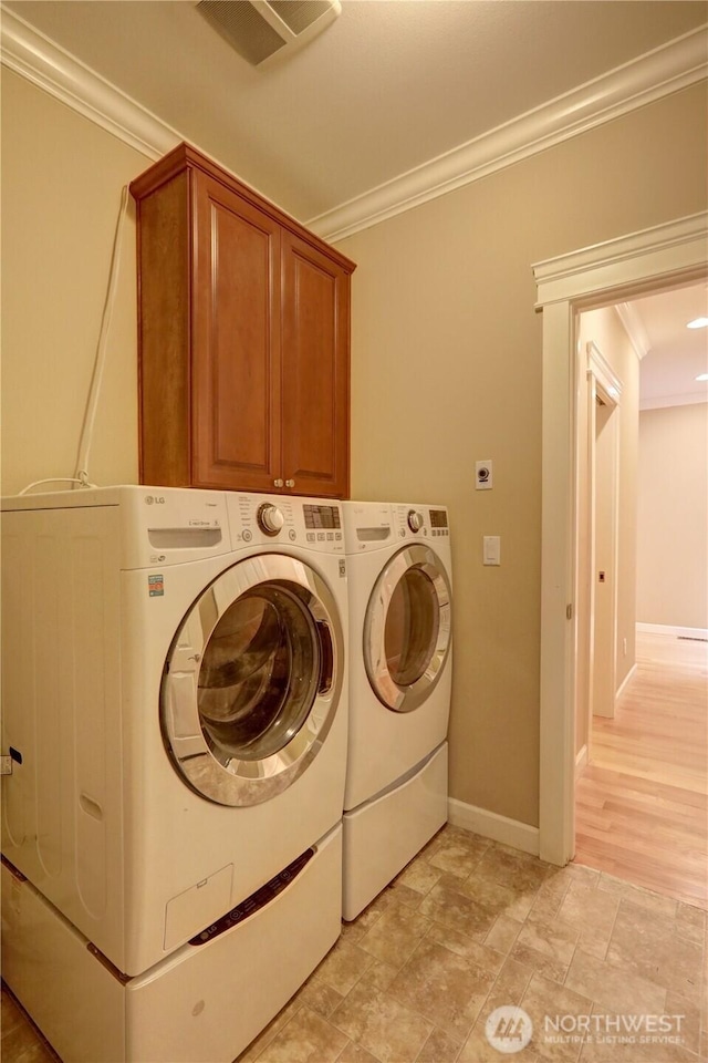 16308 Simonds Rd NE, Kenmore, WA 98028 - laundry room featuring ornamental molding, washing machine and clothes dryer, cabinet space, baseboards, and stone finish floors