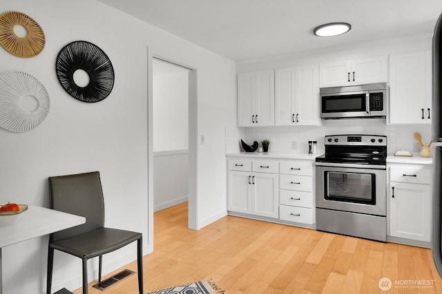 15226 116th Pl NE, Kirkland, WA 98034 - kitchen featuring stainless steel appliances, light countertops, decorative backsplash, and light wood finished floors