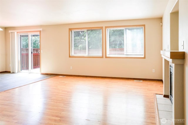 1404 102nd St E, Tacoma, WA 98445 - unfurnished living room with light wood finished floors and a fireplace with flush hearth
