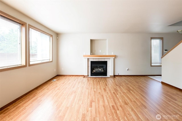 1404 102nd St E, Tacoma, WA 98445 - unfurnished living room with light wood-style flooring, a fireplace, and stairs