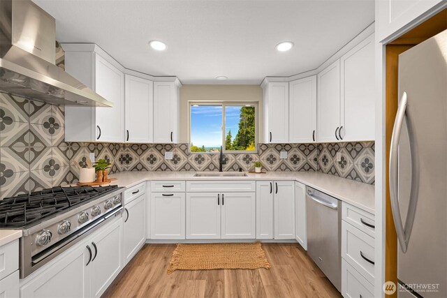 801 38th St, Bellingham, WA 98229 - kitchen with wall chimney range hood, appliances with stainless steel finishes, a sink, light countertops, and recessed lighting