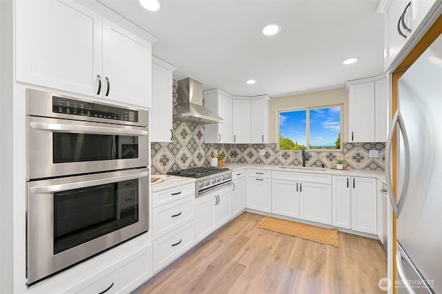 801 38th St, Bellingham, WA 98229 - kitchen featuring wall chimney exhaust hood, freestanding refrigerator, stainless steel double oven, gas stovetop, and a sink