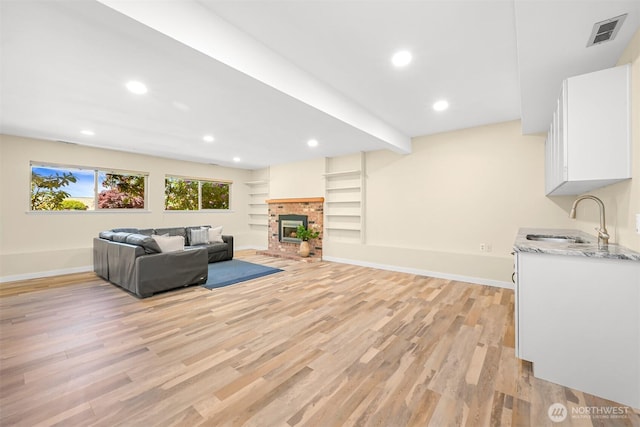 801 38th St, Bellingham, WA 98229 - unfurnished living room with light wood-type flooring, a sink, baseboards, recessed lighting, and a fireplace