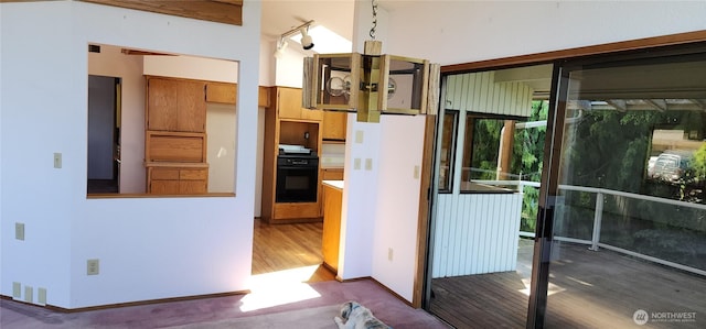10622 44th Ave SE, Everett, WA 98208 - kitchen featuring black oven, brown cabinets, wood finished floors, and baseboards