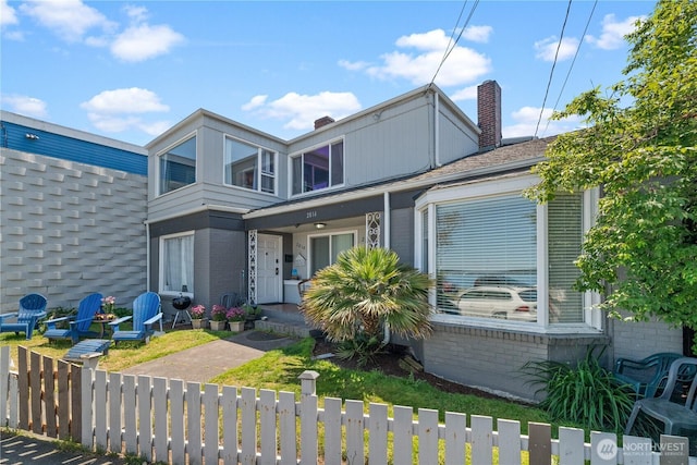 2810 Alki Ave SW, Seattle, WA 98116 - view of front of home with a fenced front yard, a chimney, and brick siding