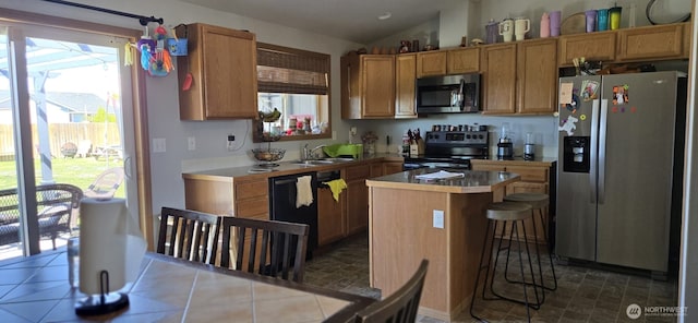 1175 E Cypress St, Othello, WA 99344 - kitchen with appliances with stainless steel finishes, a center island, a sink, light countertops, and lofted ceiling