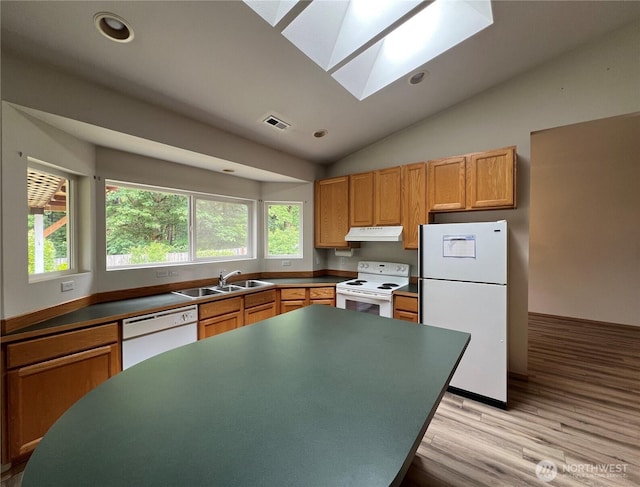 15121 148th St E, Orting, WA 98360 - kitchen with white appliances, under cabinet range hood, a skylight, vaulted ceiling, and light wood-type flooring
