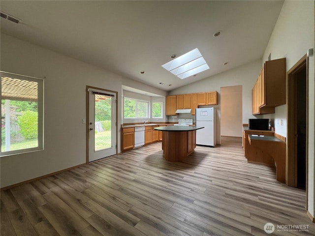 15121 148th St E, Orting, WA 98360 - kitchen with white appliances, a skylight, vaulted ceiling, under cabinet range hood, and wood finished floors