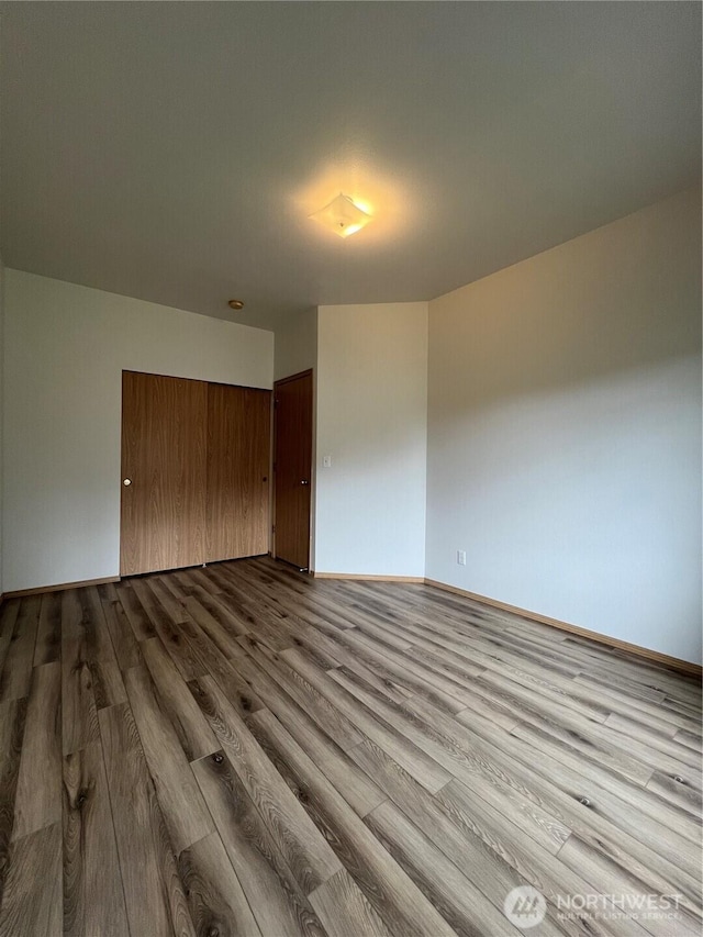 15121 148th St E, Orting, WA 98360 - unfurnished bedroom featuring dark wood-style flooring and a closet