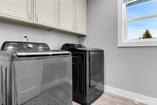 10617 Rosewood Ave Unit A, Everett, WA 98204 - laundry room with washer and clothes dryer, cabinet space, light wood-style floors, and baseboards