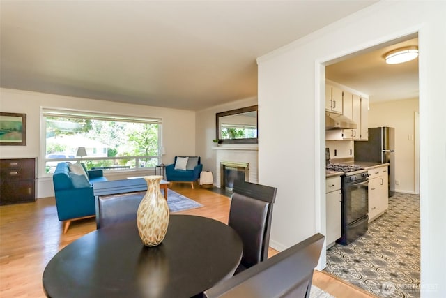 11258 29th Ave SW, Seattle, WA 98146 - dining area with a brick fireplace and light wood-style flooring
