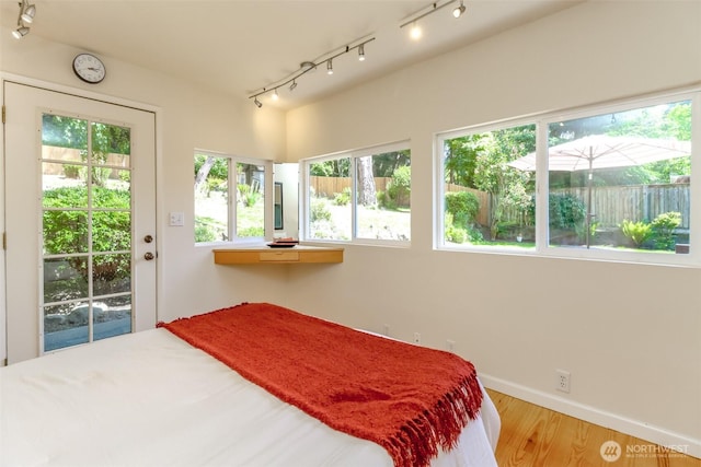 11258 29th Ave SW, Seattle, WA 98146 - bedroom featuring rail lighting, multiple windows, and wood finished floors