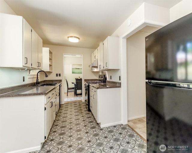 11258 29th Ave SW, Seattle, WA 98146 - kitchen featuring freestanding refrigerator, gas stove, a sink, dark countertops, and under cabinet range hood