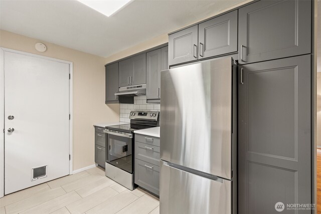 35804 15th Ave SW, Federal Way, WA 98023 - kitchen with appliances with stainless steel finishes, gray cabinetry, under cabinet range hood, tasteful backsplash, and light countertops