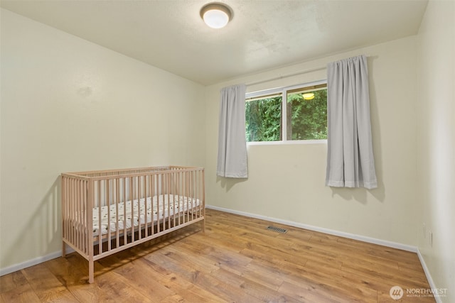 35804 15th Ave SW, Federal Way, WA 98023 - bedroom featuring wood finished floors and a nursery area