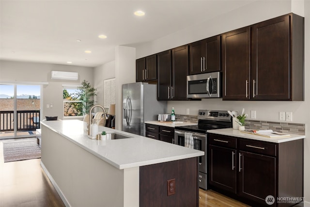 16201 Meadow Rd Unit G2, Lynnwood, WA 98087 - kitchen featuring appliances with stainless steel finishes, a sink, light wood-type flooring, a wall mounted AC, and light countertops