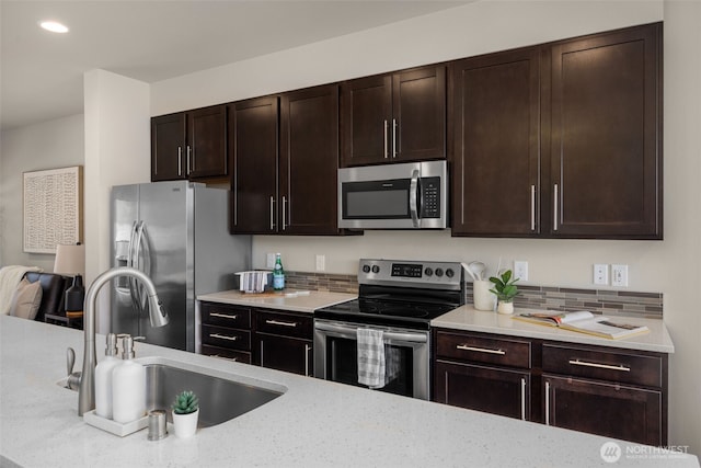 16201 Meadow Rd Unit G2, Lynnwood, WA 98087 - kitchen with stainless steel appliances, a sink, backsplash, dark brown cabinets, and recessed lighting