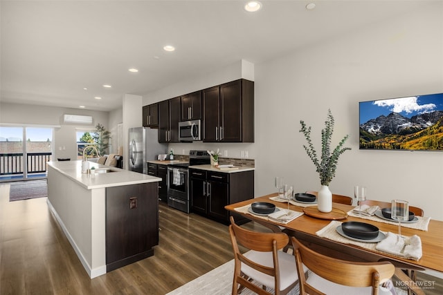 16201 Meadow Rd Unit G2, Lynnwood, WA 98087 - kitchen with stainless steel appliances, a sink, a wall unit AC, dark wood-style flooring, and light countertops