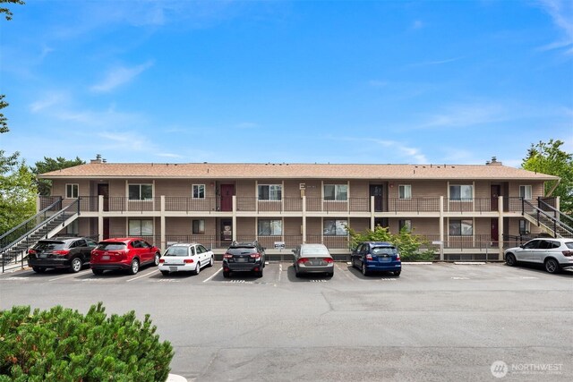 20101 61st Pl W Unit E-308, Lynnwood, WA 98036 - view of property featuring stairs and uncovered parking