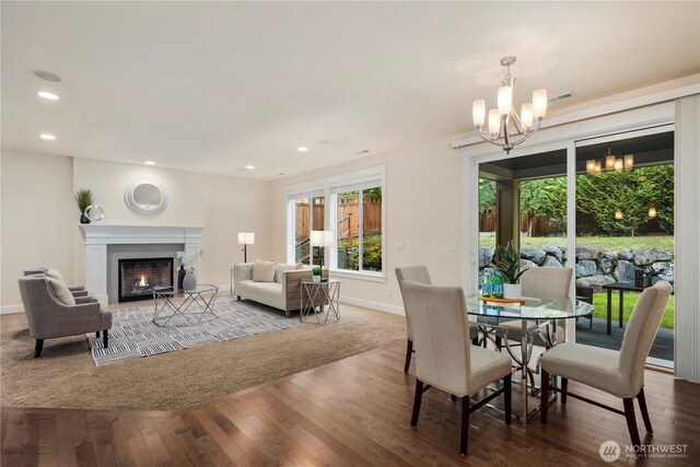24332 NE 8th Pl, Sammamish, WA 98074 - dining room featuring a chandelier, wood-type flooring, a warm lit fireplace, baseboards, and recessed lighting