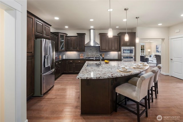 24332 NE 8th Pl, Sammamish, WA 98074 - kitchen featuring appliances with stainless steel finishes, wall chimney exhaust hood, a sink, light wood-style floors, and dark brown cabinetry