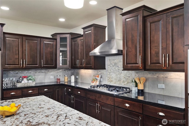 24332 NE 8th Pl, Sammamish, WA 98074 - kitchen featuring wall chimney exhaust hood, dark brown cabinetry, stainless steel gas cooktop, dark stone counters, and tasteful backsplash