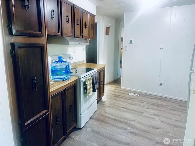 901 N Grapr Dr Unit 62, Moses Lake, WA 98837 - kitchen featuring electric stove, light wood-style flooring, under cabinet range hood, dark brown cabinets, and baseboards