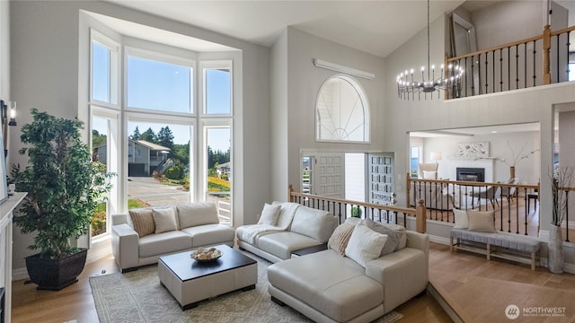 1621 Edgemoor Ln, Everett, WA 98203 - living area with high vaulted ceiling, a chandelier, wood finished floors, healthy amount of natural light, and a glass covered fireplace