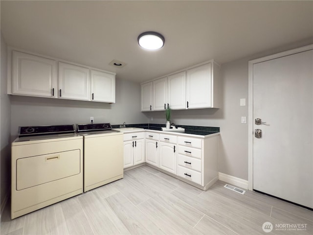 1621 Edgemoor Ln, Everett, WA 98203 - laundry area featuring washer and dryer, cabinet space, baseboards, and wood finish floors