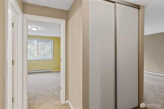 750 N 143rd St Unit 211, Seattle, WA 98133 - corridor featuring baseboard heating, carpet, and a textured ceiling