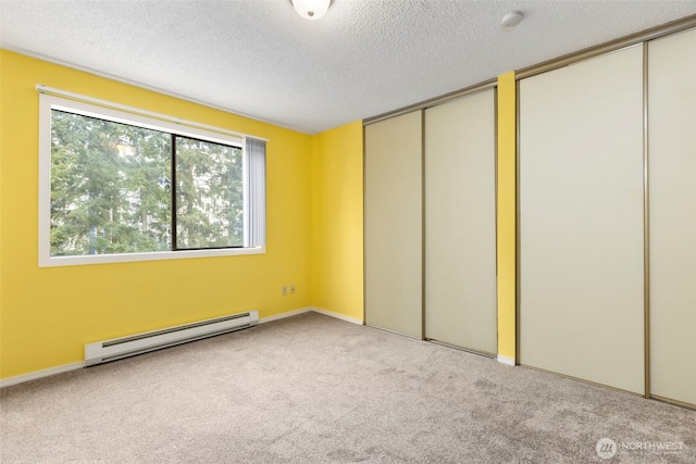 750 N 143rd St Unit 211, Seattle, WA 98133 - unfurnished bedroom featuring a baseboard heating unit, carpet flooring, two closets, and a textured ceiling
