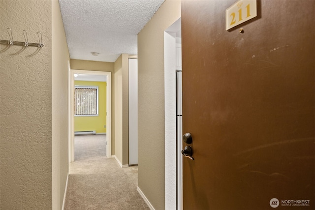 750 N 143rd St Unit 211, Seattle, WA 98133 - hallway featuring carpet, baseboard heating, a textured ceiling, a textured wall, and baseboards