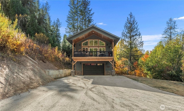 11175 Wending Ln, Leavenworth, WA 98826 - view of front of house featuring stone siding, asphalt driveway, a garage, and a balcony