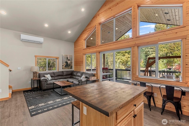11175 Wending Ln, Leavenworth, WA 98826 - living room with a wall unit AC, high vaulted ceiling, plenty of natural light, baseboards, and light wood-style floors