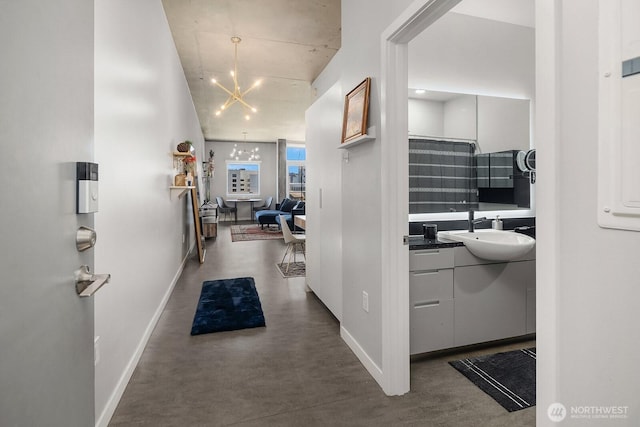 501 Roy St Unit T308, Seattle, WA 98109 - hallway featuring a sink, baseboards, a chandelier, and finished concrete floors