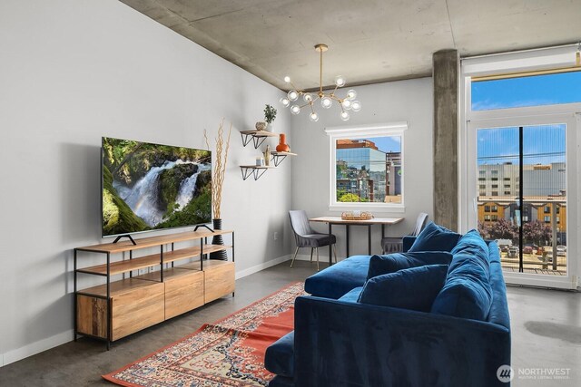 501 Roy St Unit T308, Seattle, WA 98109 - living room featuring a chandelier, healthy amount of natural light, baseboards, and concrete floors