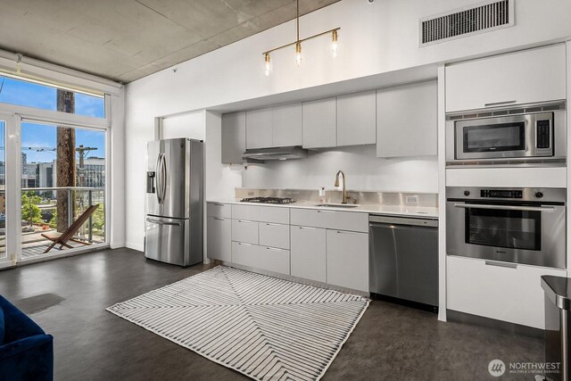 501 Roy St Unit T308, Seattle, WA 98109 - kitchen featuring appliances with stainless steel finishes, concrete floors, a sink, under cabinet range hood, and light countertops