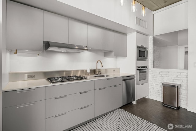 501 Roy St Unit T308, Seattle, WA 98109 - kitchen with under cabinet range hood, appliances with stainless steel finishes, a sink, and gray cabinets