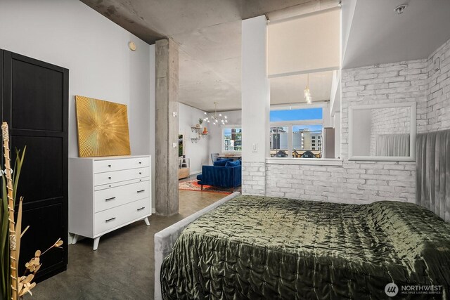 501 Roy St Unit T308, Seattle, WA 98109 - bedroom with finished concrete flooring, a chandelier, and brick wall
