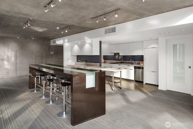 501 Roy St Unit T308, Seattle, WA 98109 - kitchen featuring modern cabinets, track lighting, dishwasher, dark carpet, and a breakfast bar area