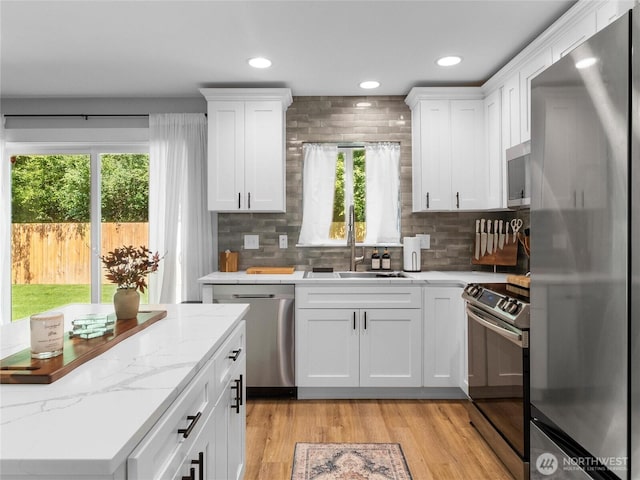 7600 Brianna Ct SE, Olympia, WA 98513 - kitchen featuring appliances with stainless steel finishes, a sink, white cabinetry, backsplash, and recessed lighting
