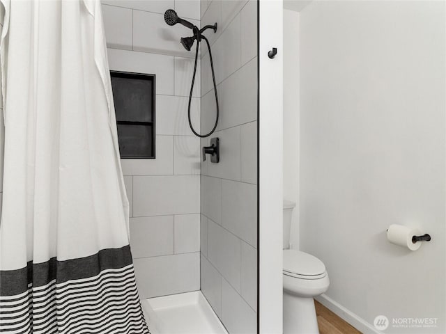 7600 Brianna Ct SE, Olympia, WA 98513 - full bath featuring a tile shower, toilet, baseboards, and wood finished floors