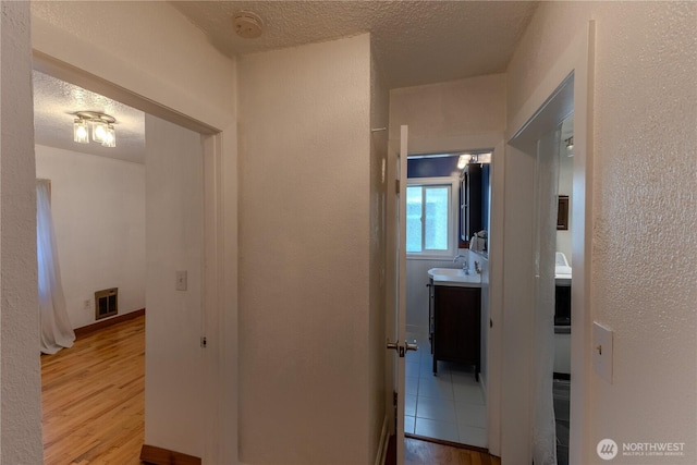 1035 Oakes Ave, Everett, WA 98201 - corridor featuring a sink, wood finished floors, a textured ceiling, and a textured wall