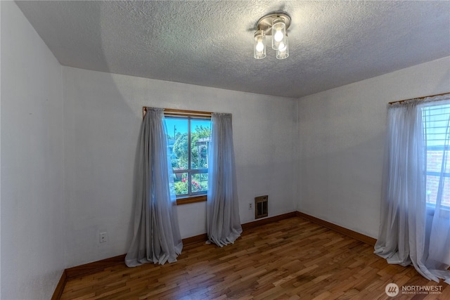 1035 Oakes Ave, Everett, WA 98201 - empty room with a textured ceiling, wood finished floors, and heating unit